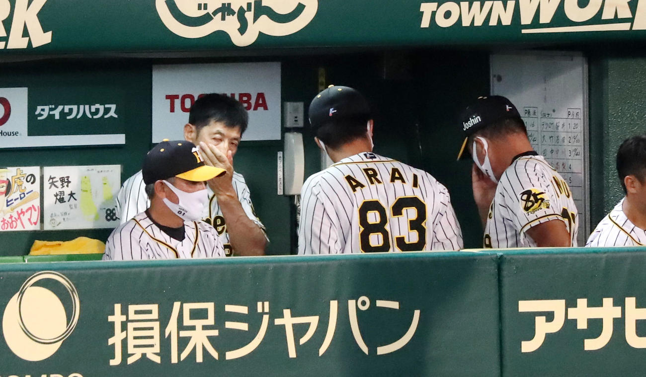 阪神対巨人　4回裏の攻撃を終えた矢野監督（左後方）は額の汗を手でぬぐう（撮影・加藤哉）