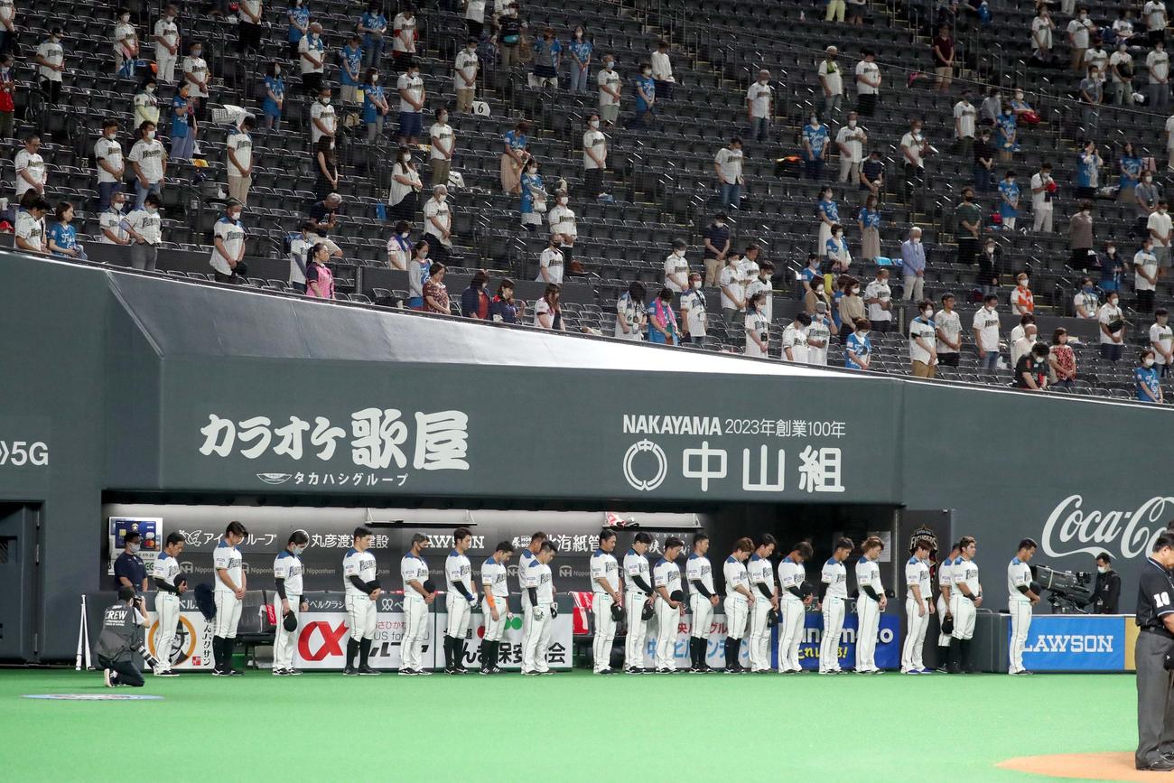 日本ハム対西武　北海道胆振東部地震から2年が経過し、試合前黙とうをする日本ハムナインとファン（撮影・佐藤翔太）