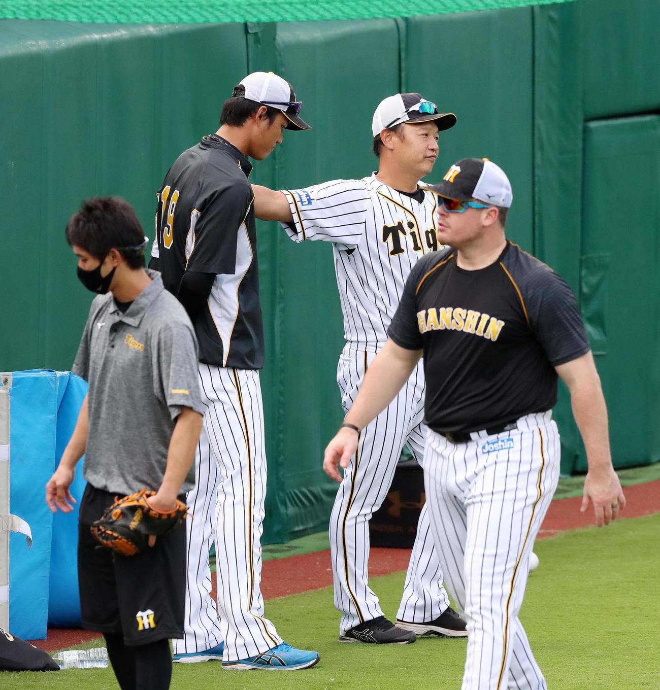 練習中、外野フェンス沿いで福原コーチ（右）と話し合った藤浪は最後に肩を叩かれる（撮影・加藤哉）
