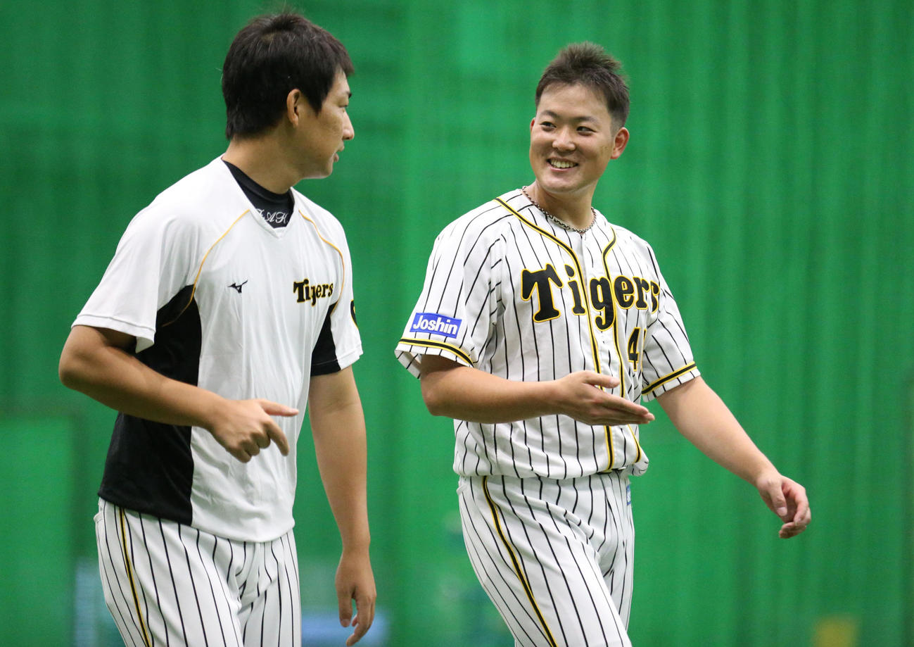 阪神対巨人　1軍合流の斎藤は岩崎（左）と笑顔で話す（撮影・上山淳一）