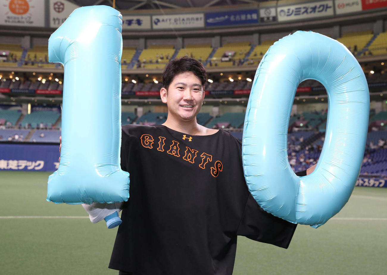 中日対巨人　中日に勝ち開幕10連勝を飾った巨人菅野は「10」のバルーンを手に笑顔で記念写真に納まる（撮影・垰建太）