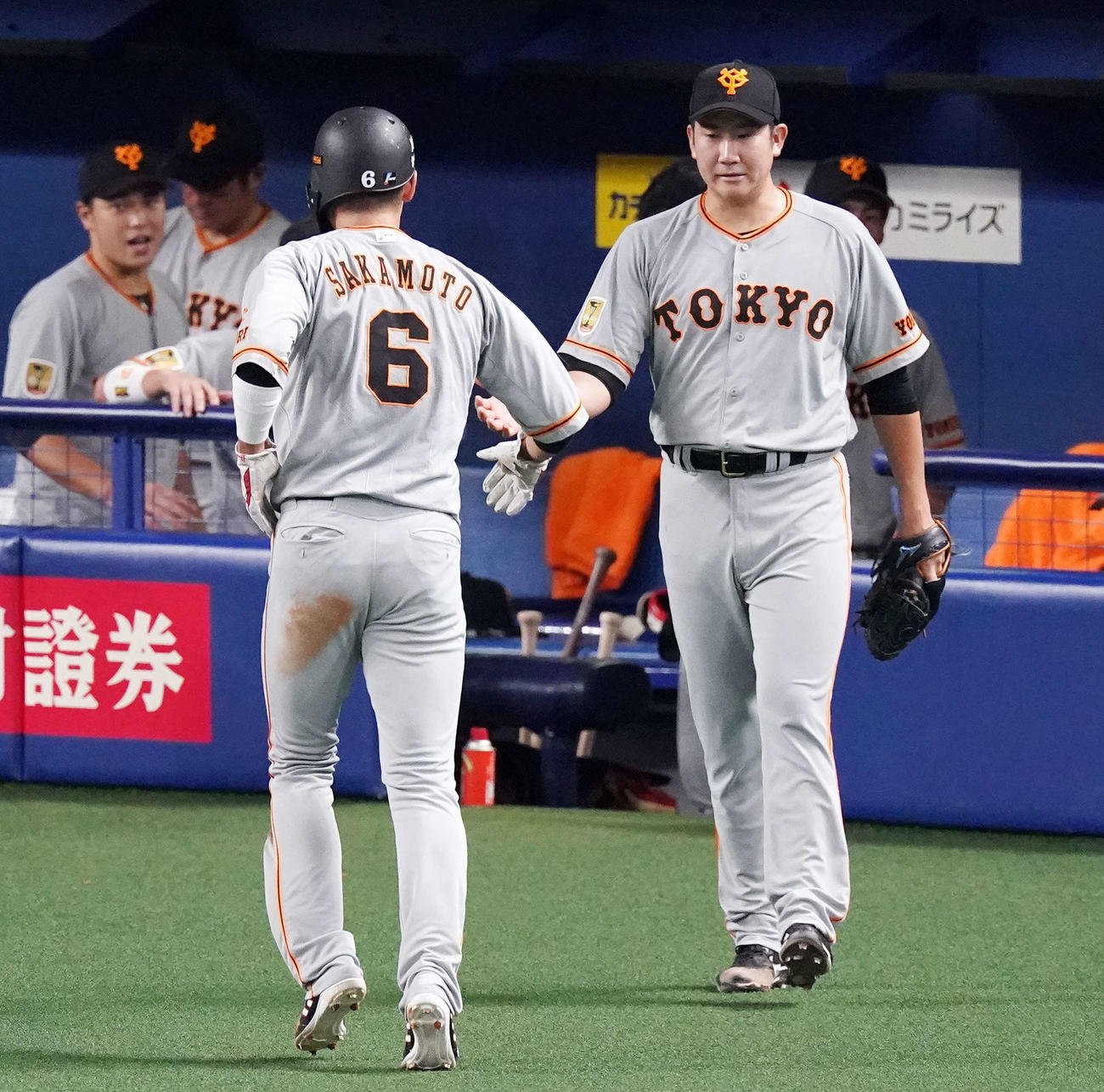 中日対巨人　3回裏開始前、巨人坂本（左）とタッチをかわしマウンドへ向かう先発の菅野（撮影・江口和貴）