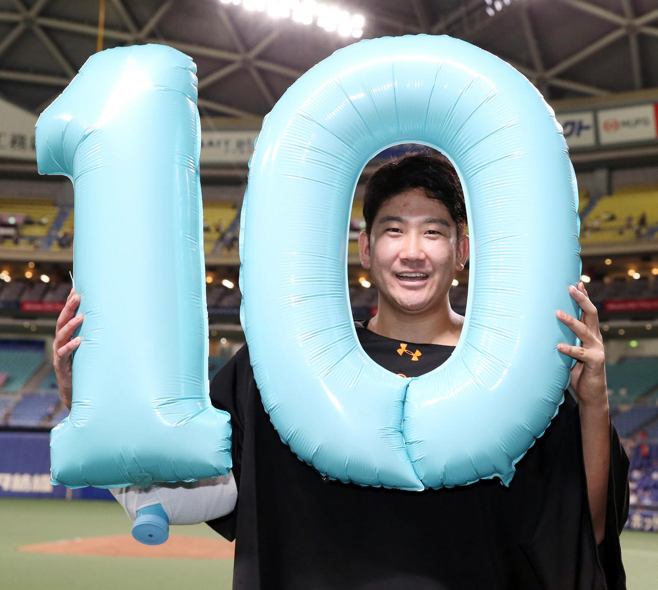 中日対巨人　中日に勝ち開幕10連勝を飾った巨人菅野は「10」のバルーンを手に笑顔で記念写真に納まる（撮影・垰建太）