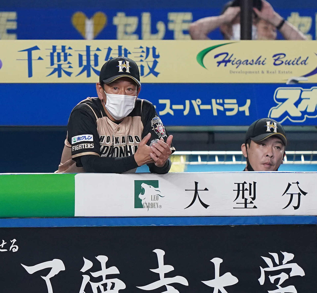ロッテ対日本ハム　9回表、浮かない表情で試合を見る日本ハム栗山監督（左）（撮影・鈴木みどり）