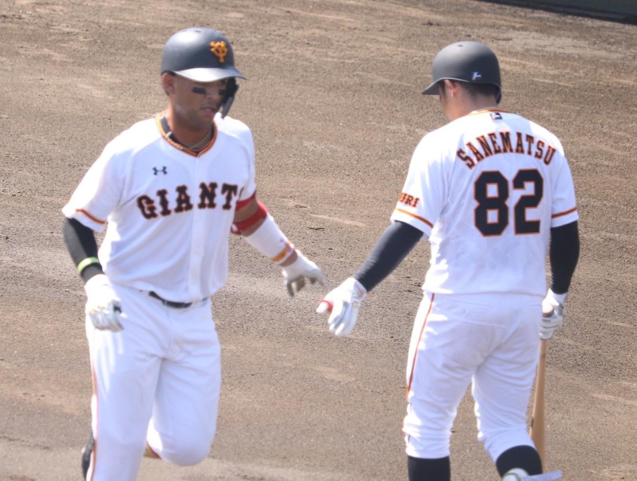 イースタン・リーグ巨人対日本ハム　初回2死一塁、右越え2ランを放ちベンチへ戻る巨人ウレーニャ（左）。右の香月はユニホームの準備が間に合わず実松2軍バッテリーコーチのものを着用する（撮影・久永壮真）