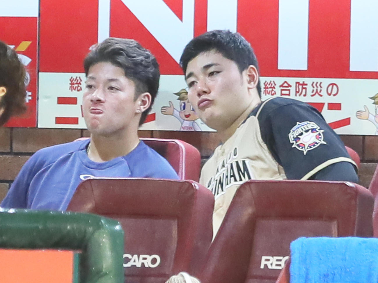 楽天対日本ハム　試合再開を待つ間、ベンチで渋い表情を見せる日本ハムの吉田輝（左）と清宮（撮影・足立雅史）