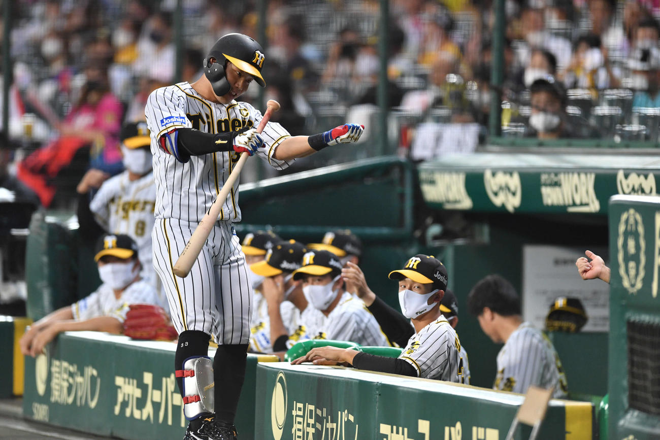 1回裏阪神無死一、二塁、投犠打を成功させ、ベンチ前で犠打のポーズをとる糸原健斗（撮影・岩下翔太）