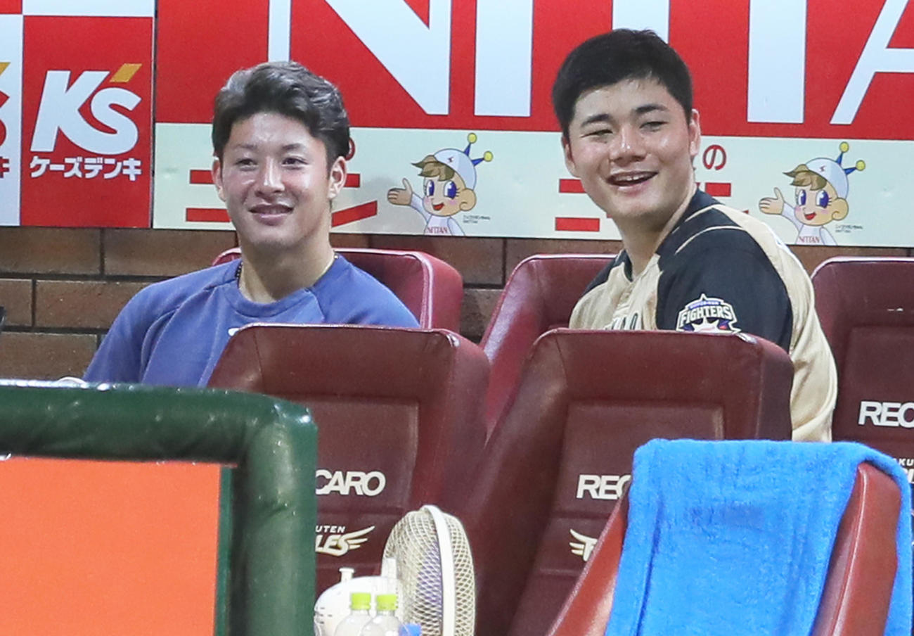 楽天対日本ハム　試合再開を待つ間、ベンチで笑顔を見せる日本ハムの吉田輝（左）と清宮（撮影・足立雅史）