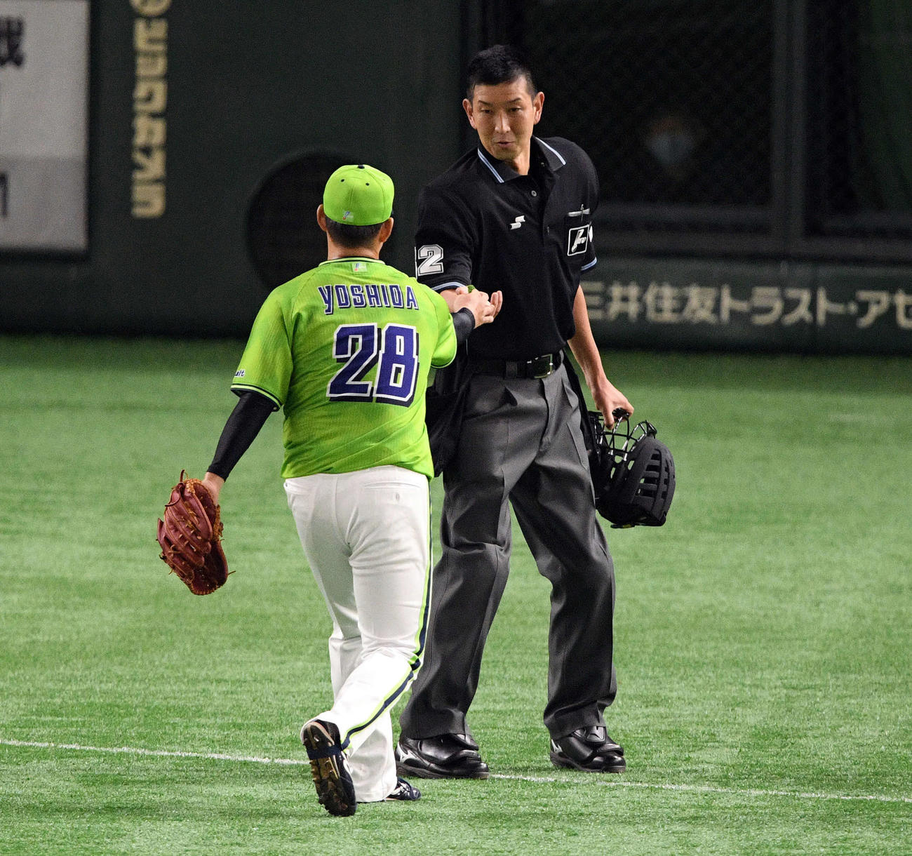 巨人対ヤクルト　2回裏、ヤクルト吉田喜（手前）は球審に何かを手渡す（撮影・滝沢徹郎）