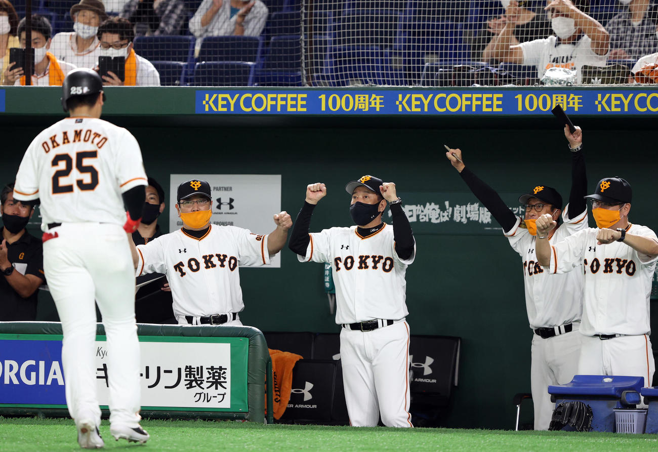 巨人対ヤクルト　7回裏巨人1死、ソロ本塁打を放った岡本（手前）をエアゴータッチで迎える原監督（中央）ら巨人ベンチ（撮影・狩俣裕三）
