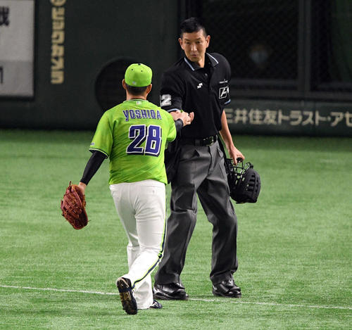 巨人対ヤクルト　2回裏、ヤクルト吉田喜（手前）は球審に何かを手渡す（撮影・滝沢徹郎）