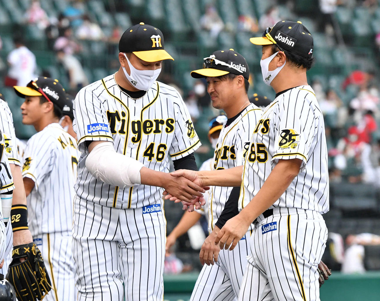 8回途中1失点で5勝目をあげ、福原忍投手コーチ（右）と握手を交わす秋山拓巳（撮影・岩下翔太）