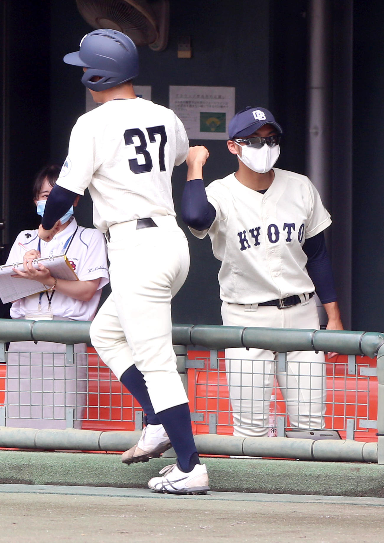 大対京大　3回裏京大2死三塁、野田の左前適時打で生還の鈴木（手前）を出迎える京大の近田助監督（撮影・上山淳一）