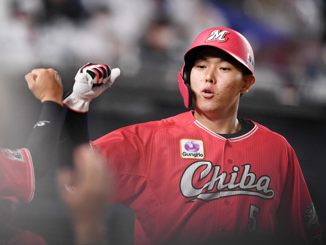 ロッテ対オリックス　7回裏終了時、ナインとタッチを交わすロッテ安田（撮影・横山健太）