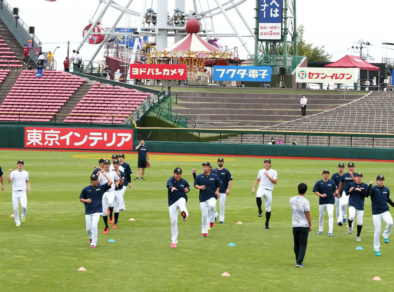 球場入りしアップする日本ハムナイン（撮影・黒川智章）