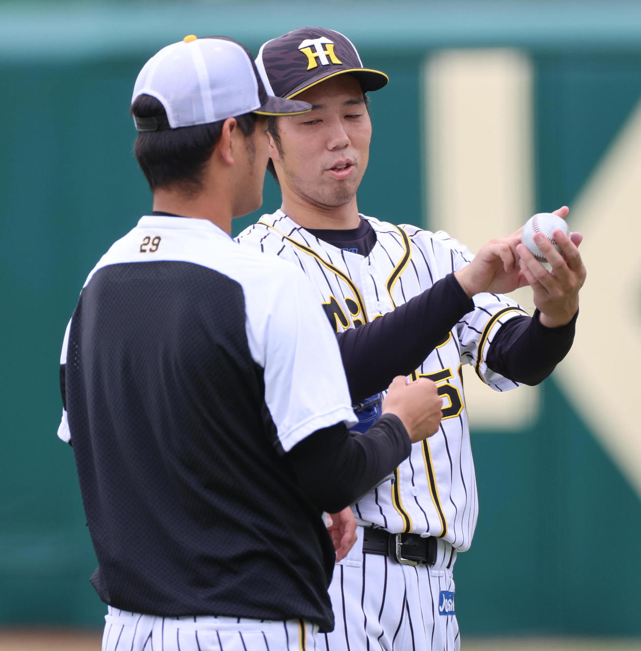 高橋遥人（左）は青柳晃洋から変化球についてアドバイスを受ける（撮影・清水貴仁）