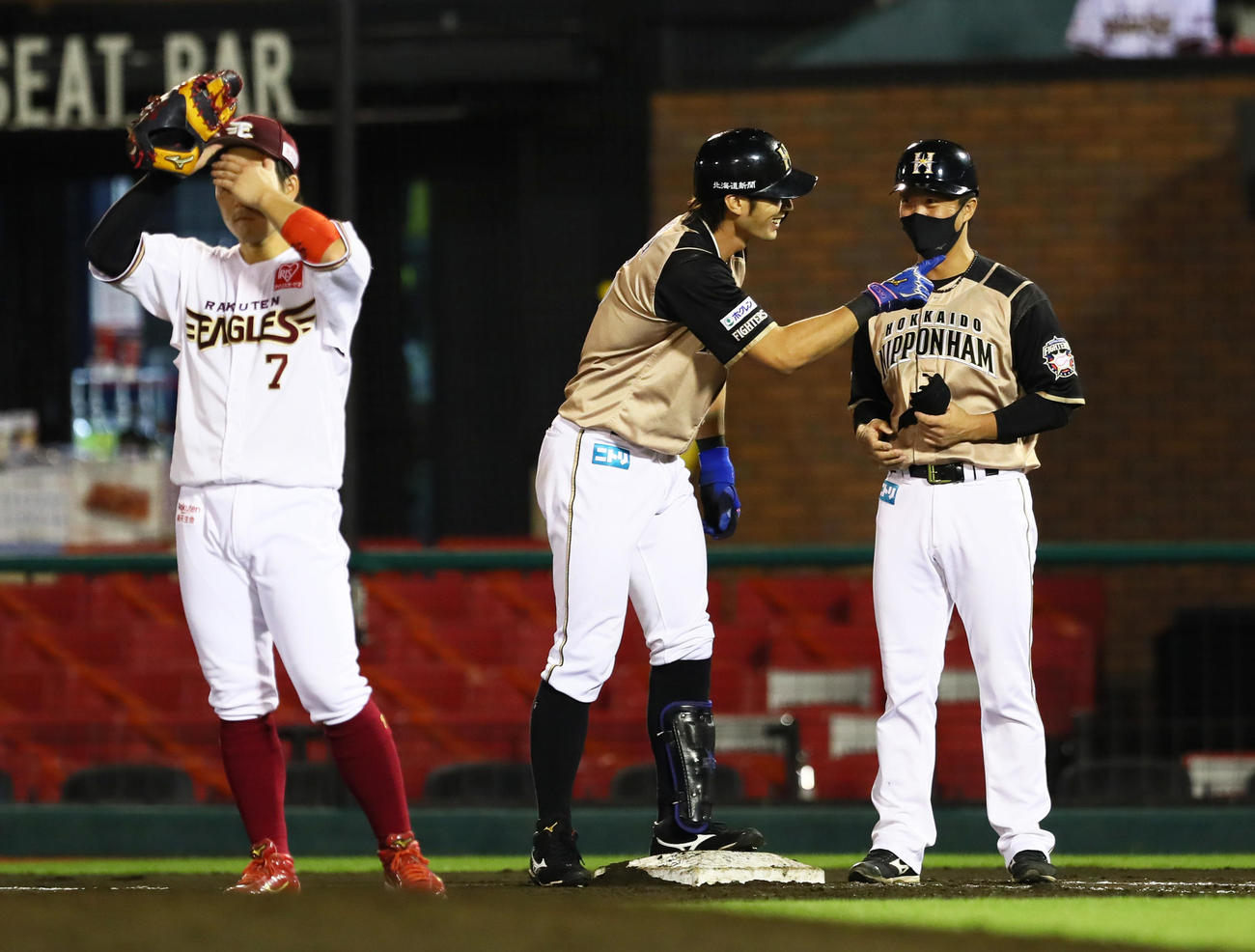 楽天対日本ハム　7回表日本ハム1死一、三塁、左前適時打を放ちベンチに笑顔を見せる大田（中央）（撮影・足立雅史）
