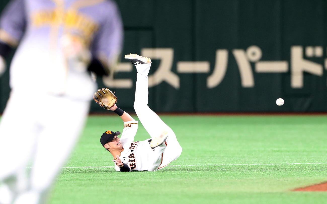 巨人対阪神　9回表阪神1死一、二塁、吉川尚は近本の打球を横っ跳びで好捕しカバーに入る増田大へボールをトスする（撮影・加藤哉）