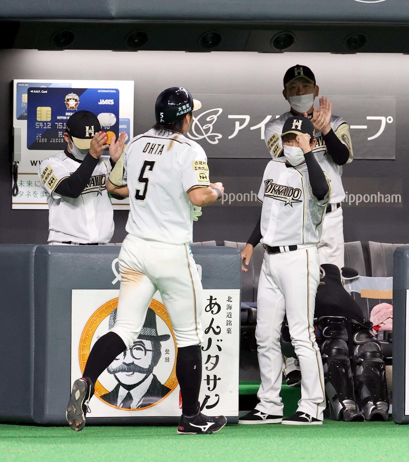 日本ハム対ソフトバンク　2回裏日本ハム無死一、二塁、ビヤヌエバの左前適時打で生還した大田（左手前）を出迎える栗山監督（撮影・佐藤翔太）