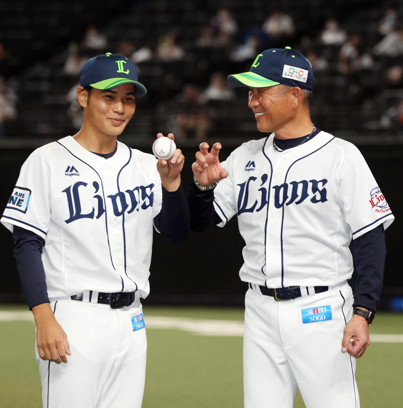 西武対ロッテ　プロ初勝利し、記念撮影のポーズを辻監督（右）からレクチャーされる浜屋（撮影・狩俣裕三）