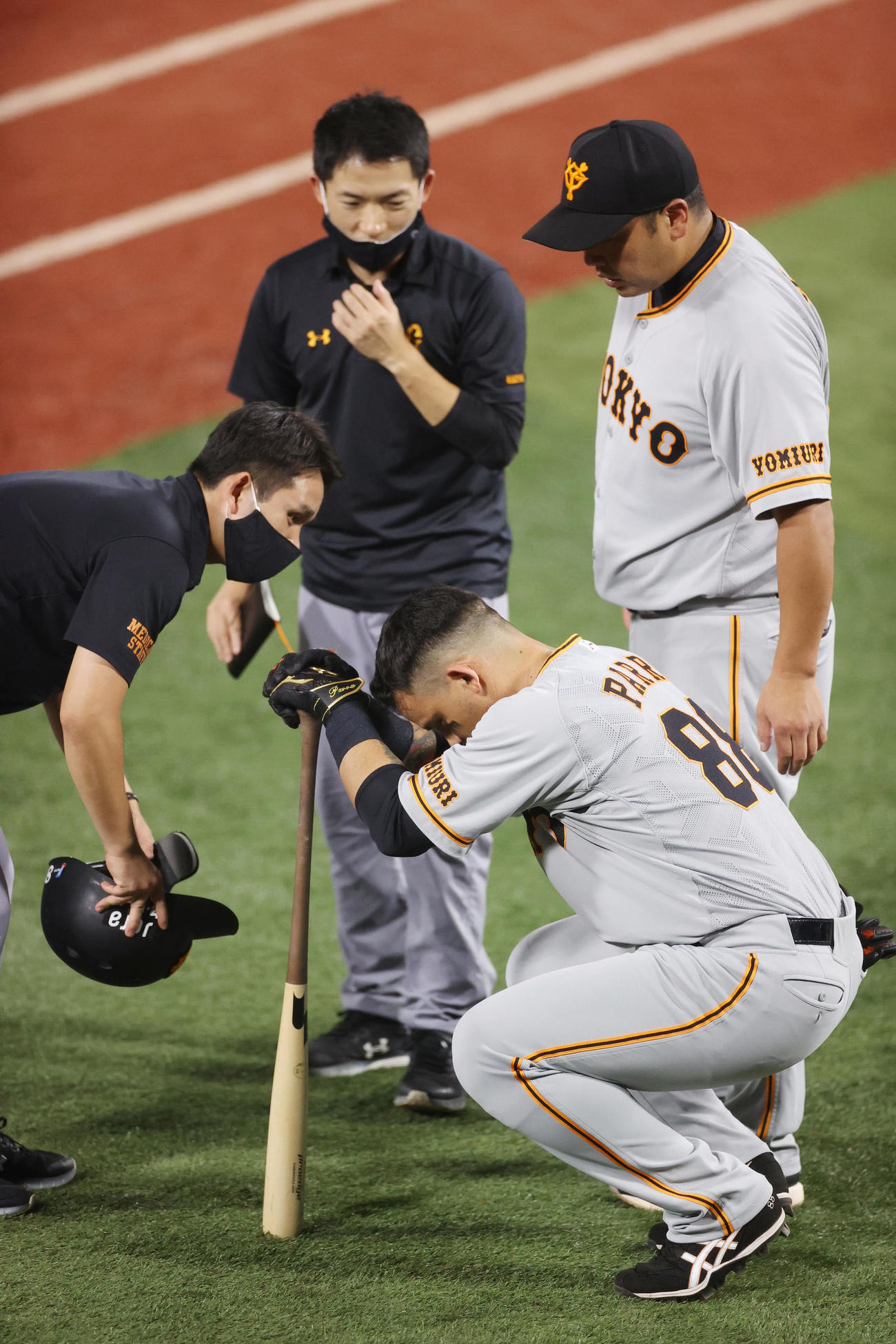 DeNA対巨人　1回表巨人2死、自打球が足に当たり、痛がるパーラ（手前）を心配する阿部ヘッドコーチ代行（右）（撮影・狩俣裕三）
