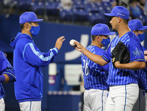 DeNA対巨人　9回を締めた三上（右）からウイニングボールを手渡される井納（撮影・丹羽敏通）