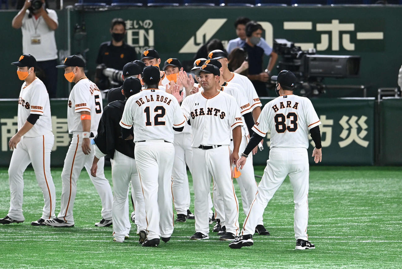 巨人対阪神　阿部ヘッドコーチ代行（中央）は選手とエアタッチでナインを出迎える（撮影・山崎安昭）