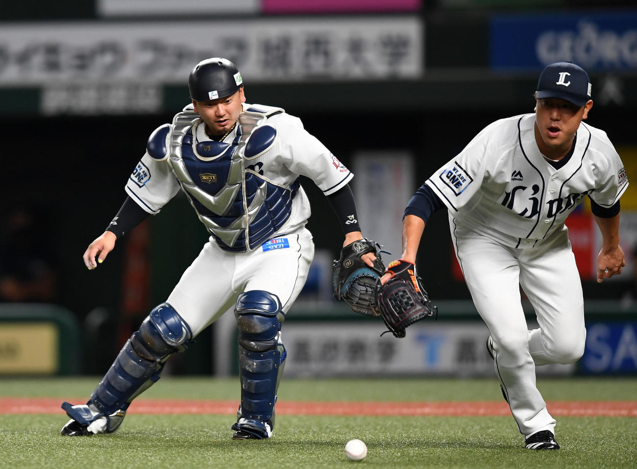 西武対ロッテ　2回表ロッテ無死二塁、菅野のバントを後逸する森（左）。右は内海（撮影・横山健太）