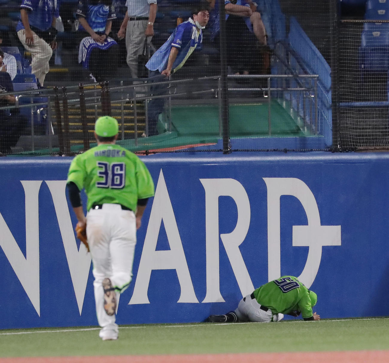 ヤクルト対DeNA　9回表DeNA2死、山下の打球をフェンスに激突しながら好捕した上田（右）は、立ち上がれずにうずくまる（2020年9月16日撮影）