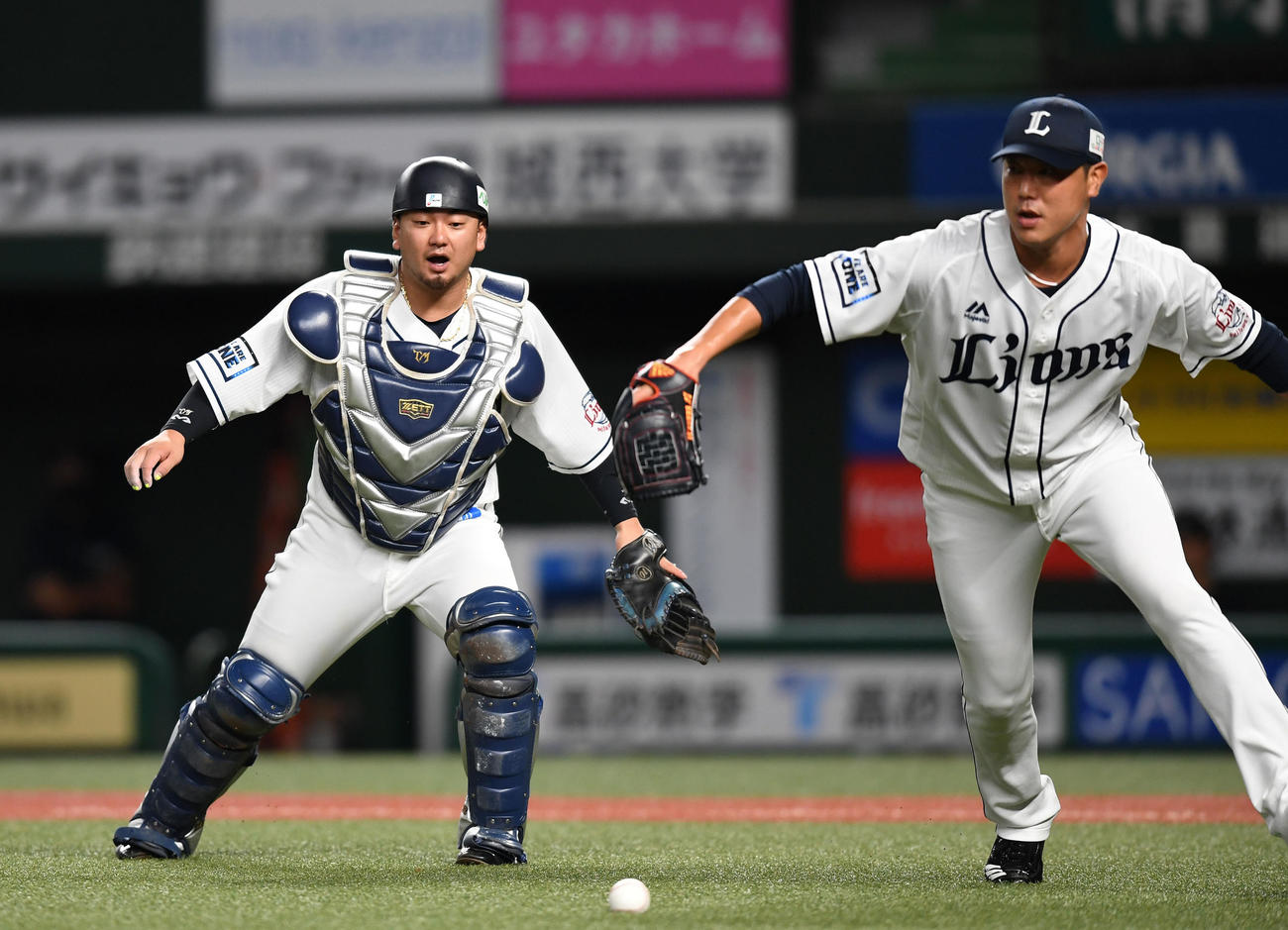 西武対ロッテ　2回表ロッテ無死二塁、菅野のバントを後逸する森（左）。右は内海（撮影・横山健太）