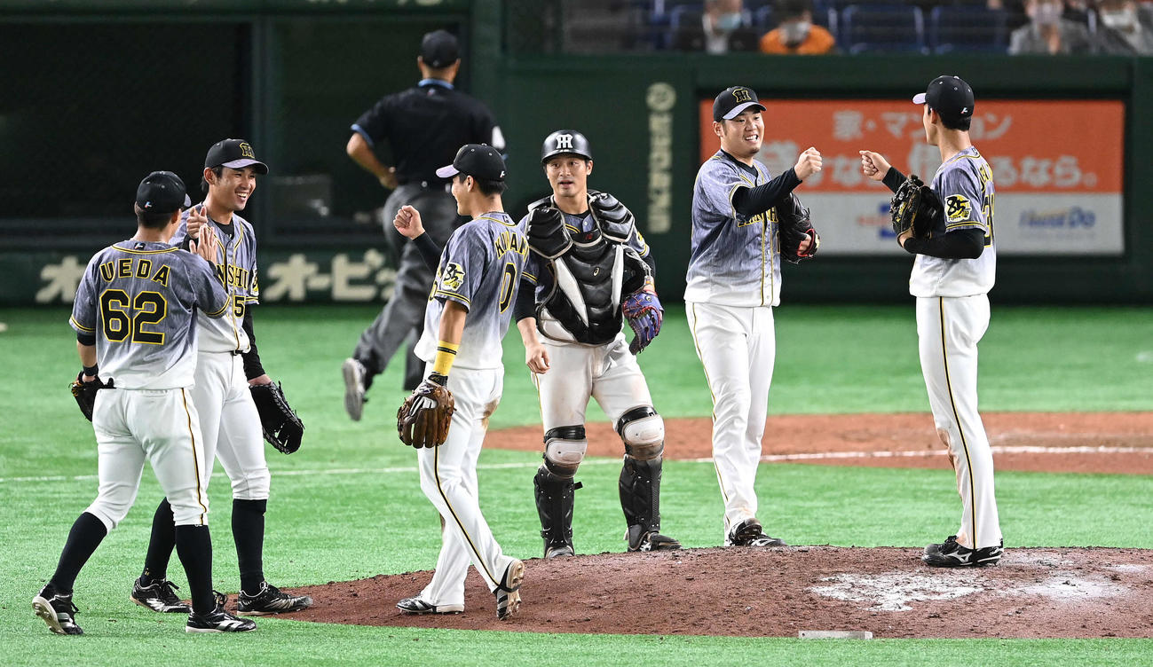 巨人対阪神　完封勝利の西勇（右から2人目）はナインと笑顔でタッチを交わす（撮影・鈴木みどり）
