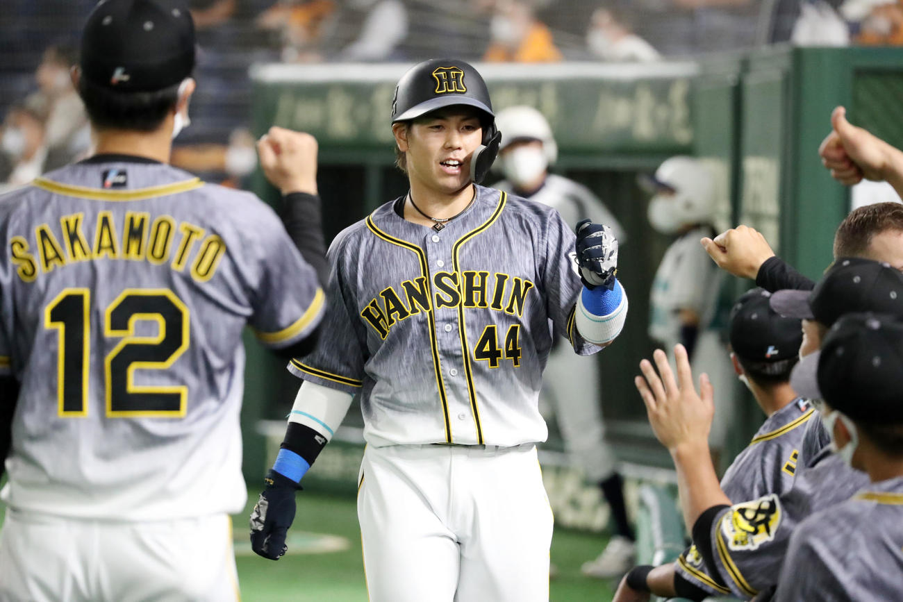 巨人対阪神　1回表阪神2死満塁、梅野は陽川の押し出し四球で生還しベンチのナインとエアタッチする（撮影・加藤哉）