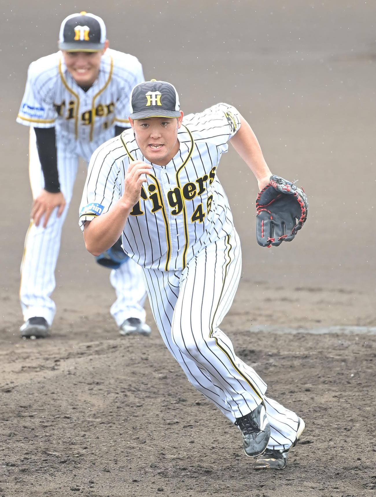 ノックの打球を追う阪神・斎藤友貴哉。左奥は阪神・西純矢（2020年9月18日・代表撮影）