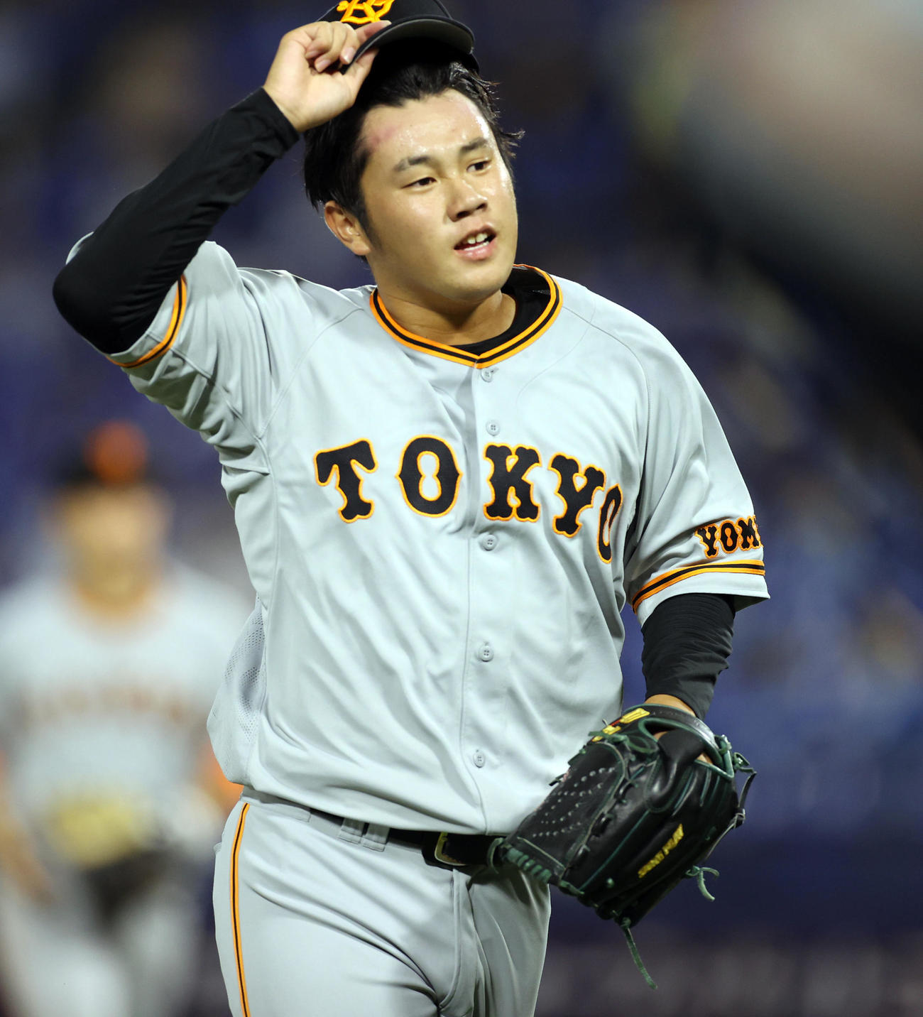 DeNA対巨人　6回裏を抑え、グラブをたたきながらベンチへ戻る堀岡（撮影・狩俣裕三）