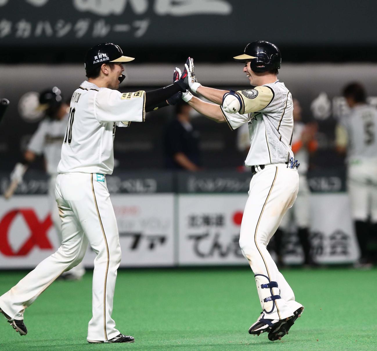 日本ハム対ロッテ　4回裏日本ハム2死一塁、左越え2点本塁打を放ち清水（左）とタッチする松本（撮影・黒川智章）