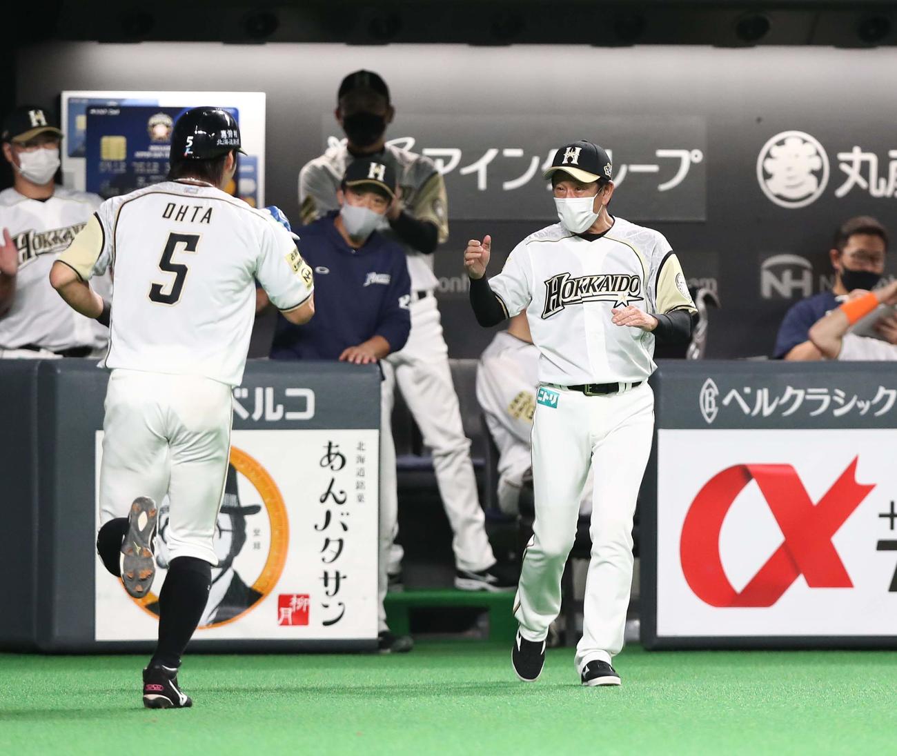 日本ハム対ロッテ　3回裏、2点適時二塁打を放った大田を出迎える栗山監督（撮影・黒川智章）