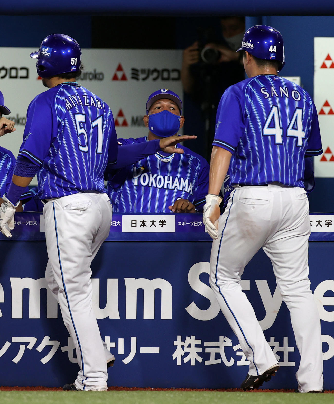 DeNA対巨人　2回裏DeNA1死二、三塁、倉本寿彦の2点適時打で生還した宮崎（左）、佐野（右）をアイーンポーズで迎えるラミレス監督（撮影・狩俣裕三）