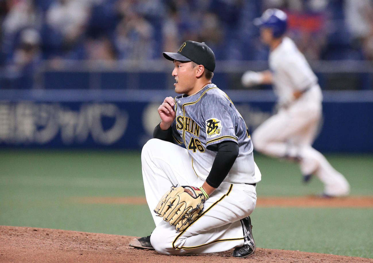 中日対阪神　4回裏中日2死二、三塁、秋山（手前）は阿部に左越え先制3点本塁打を浴び、マウンドに座り込む（撮影・上山淳一）
