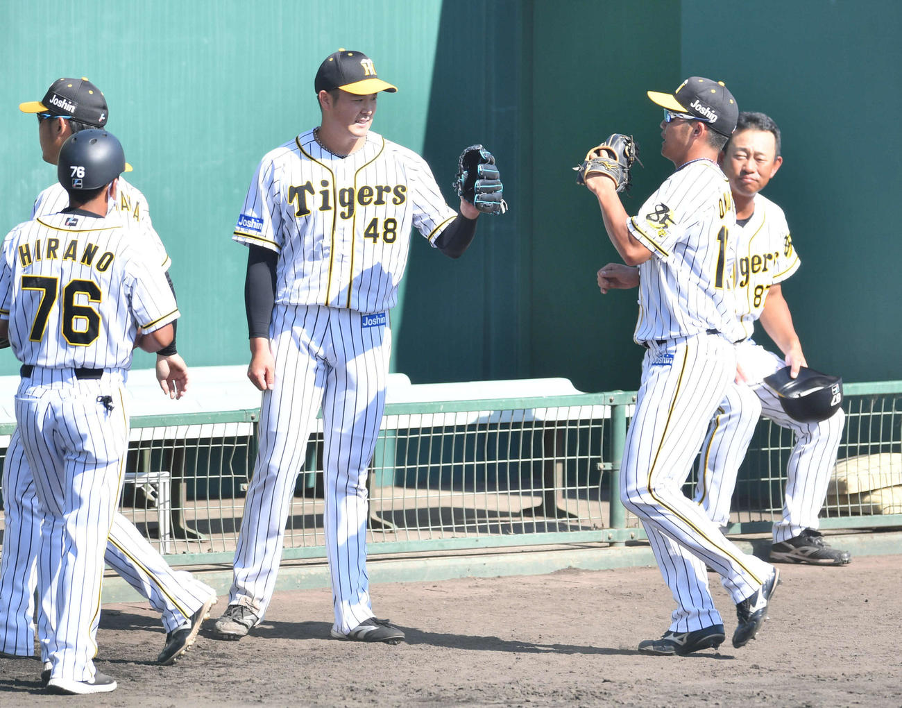 ウエスタン・リーグ阪神対中日　6回表終了後、藤井の中飛を好守した小野寺（右から2人目）とグラブタッチする斎藤（撮影・岩下翔太）
