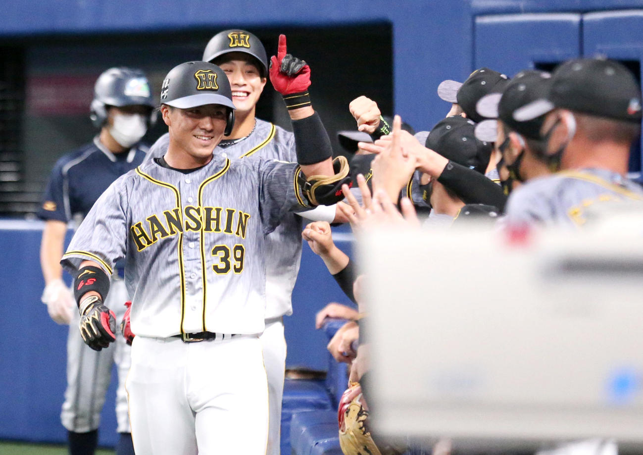 中日対阪神　3回表阪神無死一塁、代打長坂（手前左）は左中間に2点本塁打を放ち、ナインに笑顔を見せる（撮影・上山淳一）