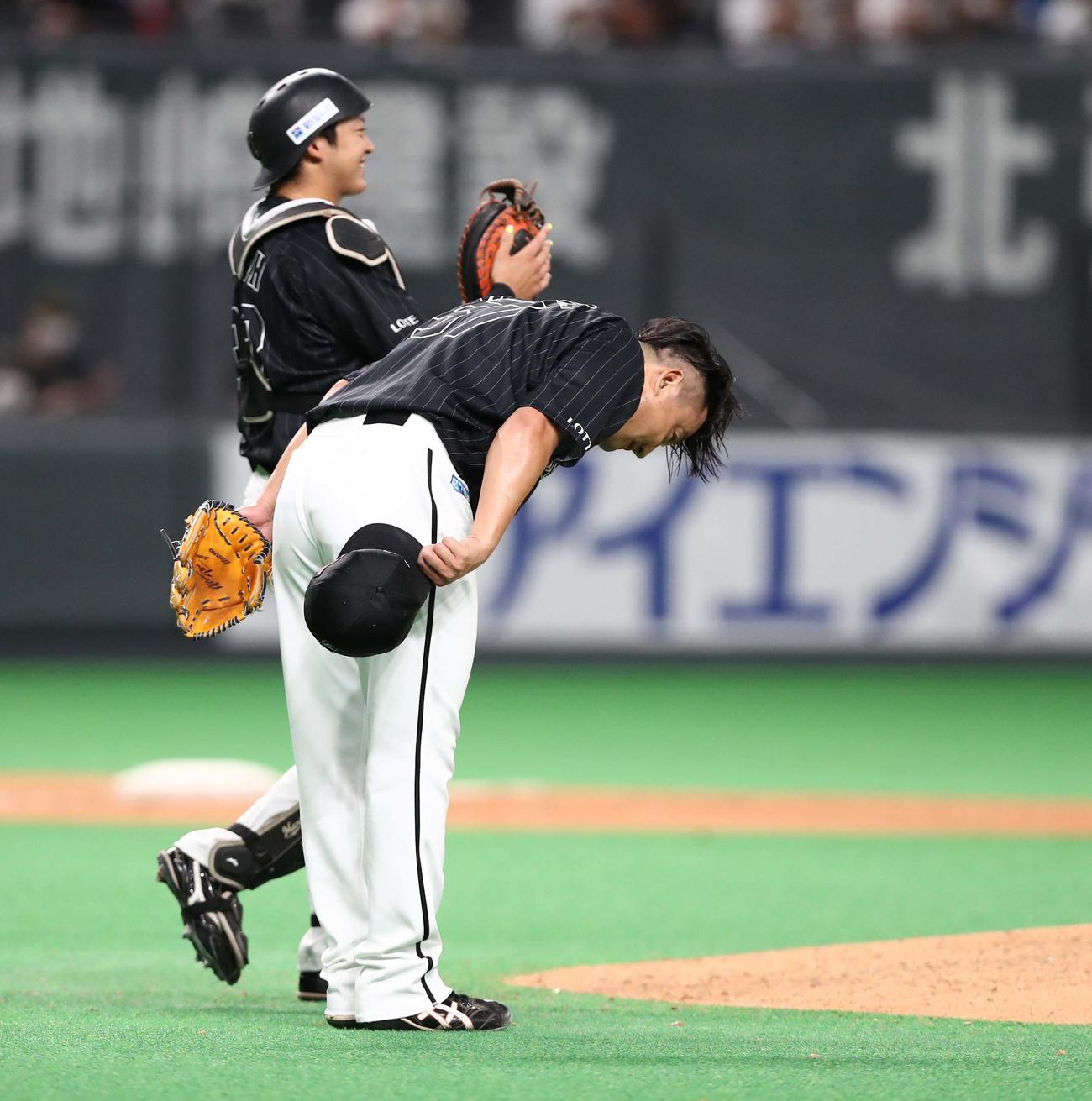 日本ハム対ロッテ　3四球を与えながら移籍後初セーブを挙げた沢村は、野手に頭を下げる（撮影・黒川智章）