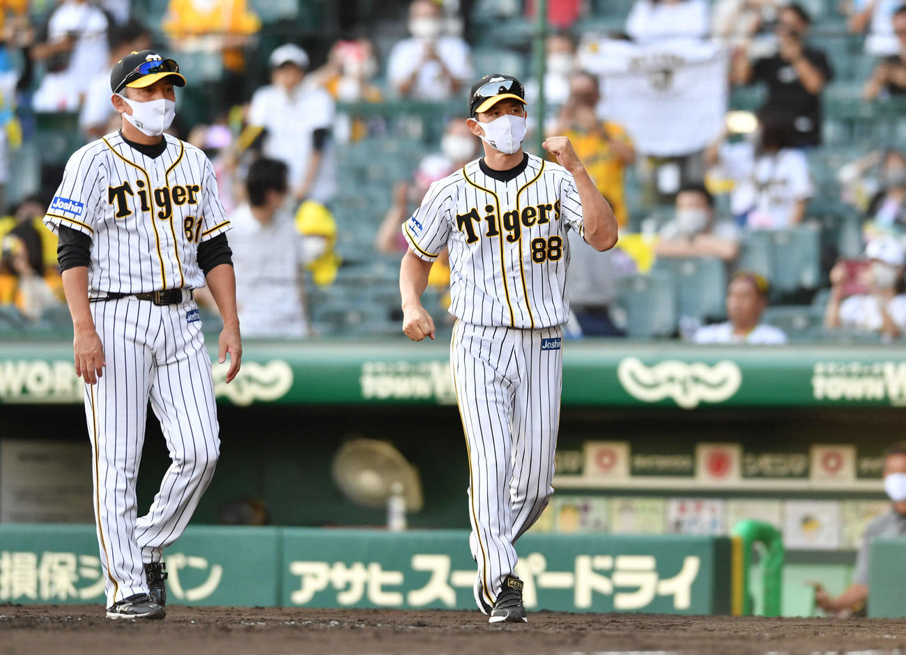 阪神対DeNA　DeNAに勝利し、ガッツポーズしながら整列へ向かう矢野監督。左は清水ヘッドコーチ（撮影・岩下翔太）
