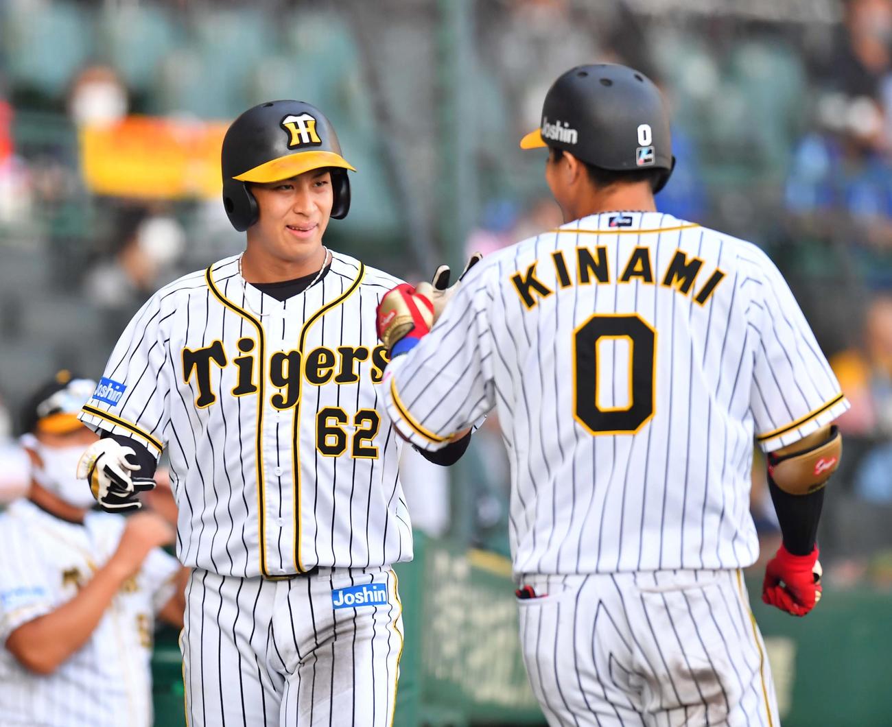 阪神対DeNA　8回裏阪神1死三塁、木浪聖也（右）の中犠飛で生還し笑顔でエアタッチする植田海（撮影・上田博志）