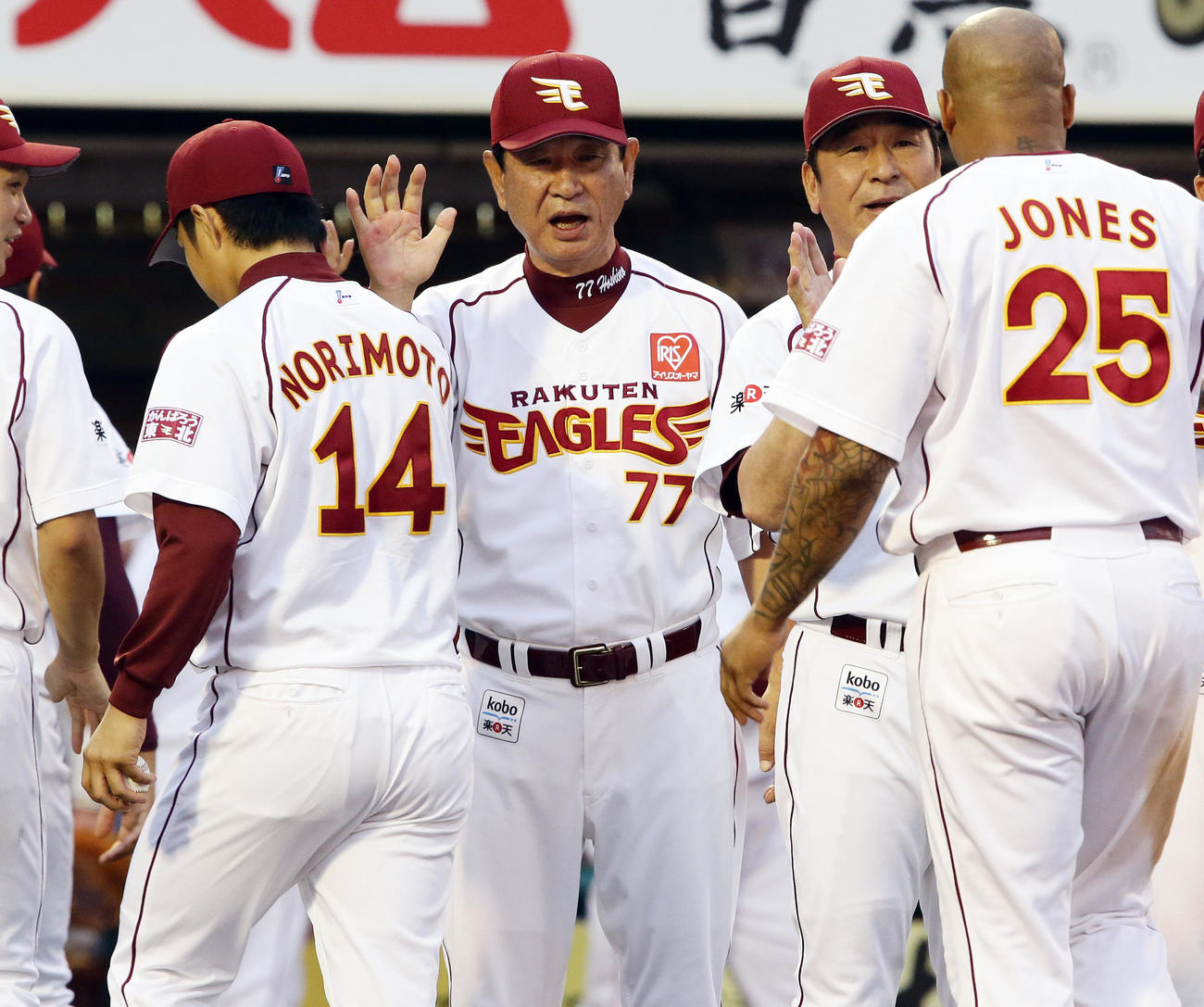 勝利投手の則本（左）、ソロ本塁打を放ったジョーンズ（右）を笑顔で迎える星野監督（中央）（2013年7月13日）