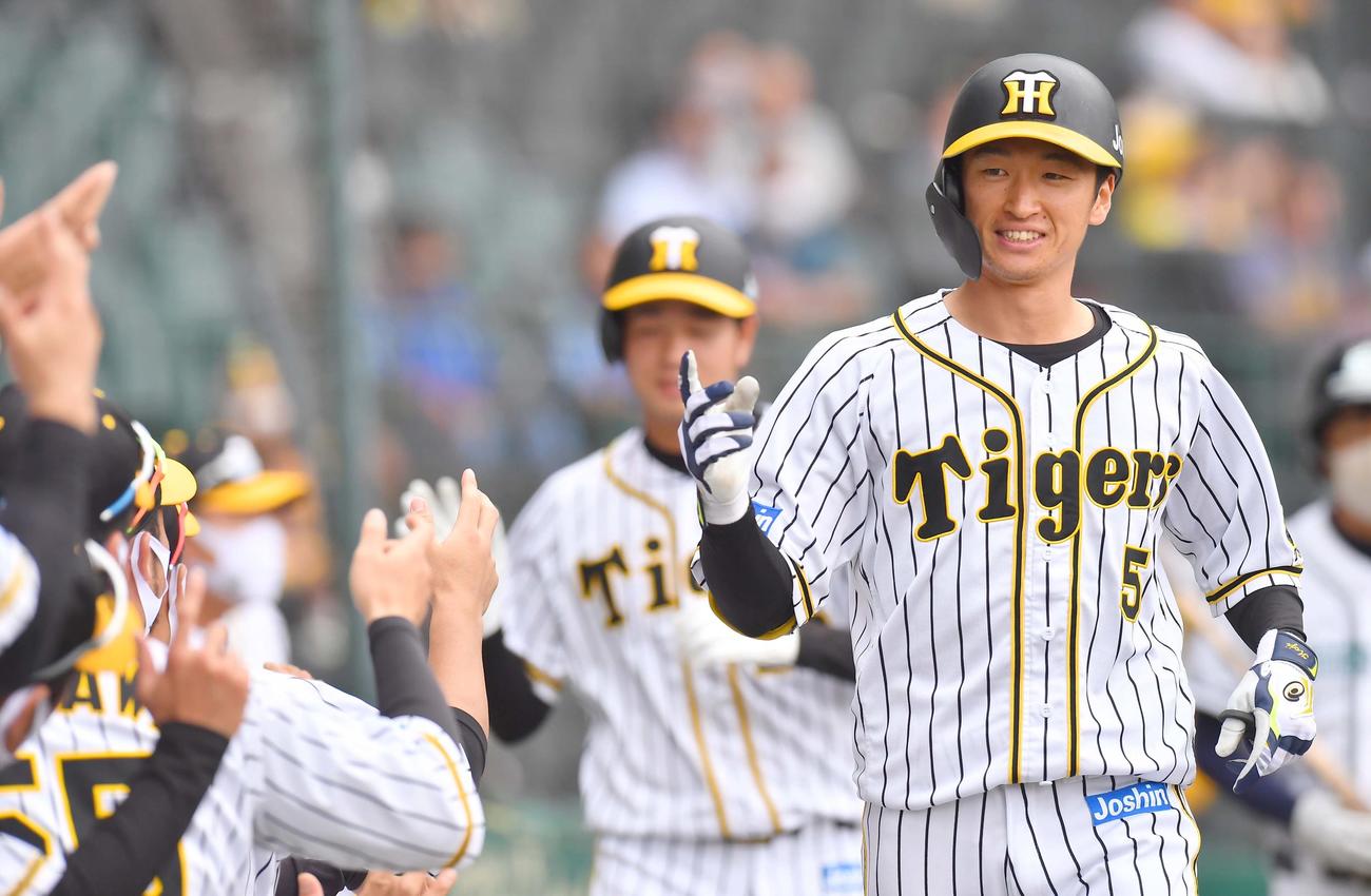阪神対DeNA　3回裏阪神2死一塁、右中間へ先制2点本塁打を放った近本光司はナインの出迎えに笑顔を見せる（撮影・上田博志）