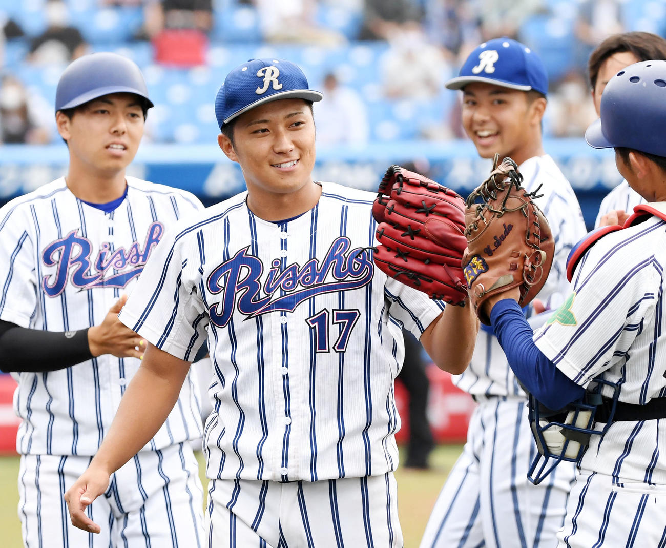 亜大対立正大　亜大に勝利しナインとタッチをかわす立正大・糸川（撮影・横山健太）