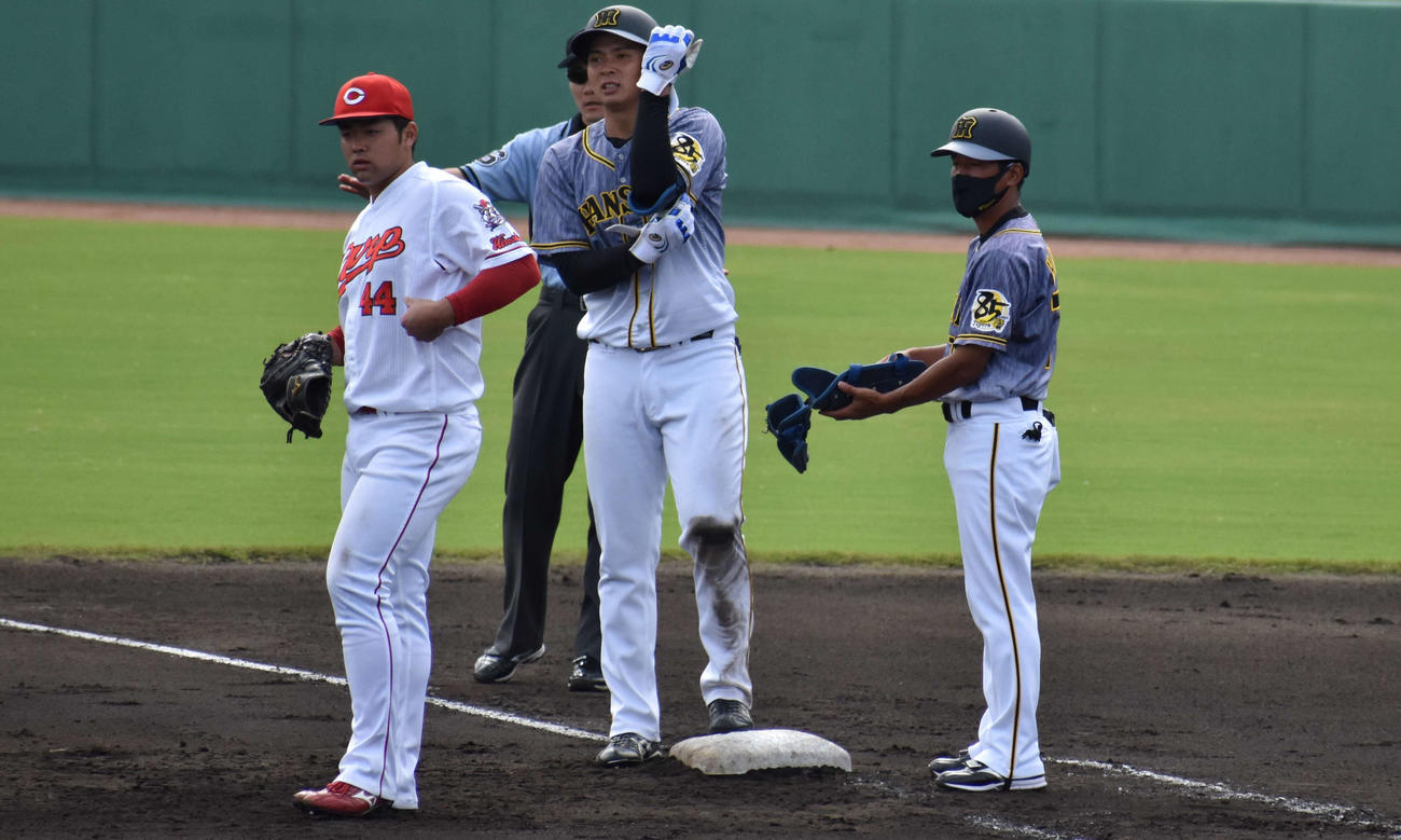 ウエスタン・リーグ広島戦で、8回1死三塁に左前へ決勝適時打を放った阪神ドラフト2位の井上広大外野手。右は平野コーチ（撮影・只松憲）