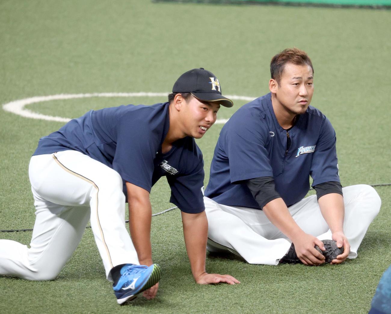 西武対日本ハム　試合前、言葉を交わす日本ハム樋口と中田（右奥）（撮影・佐藤翔太）