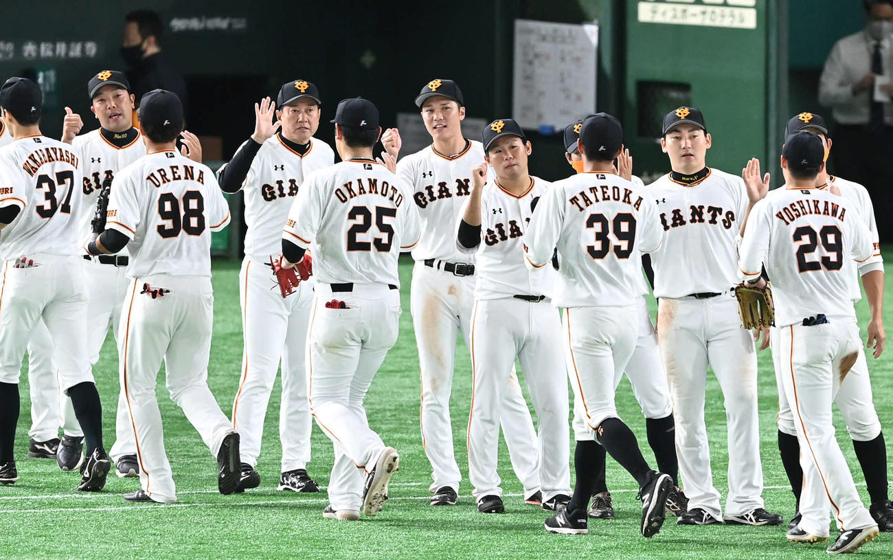 巨人対広島　坂本（中央）は5勝目を挙げた巨人田口（同右）原監督（同左）らとエアタッチをかわす（撮影・山崎安昭）