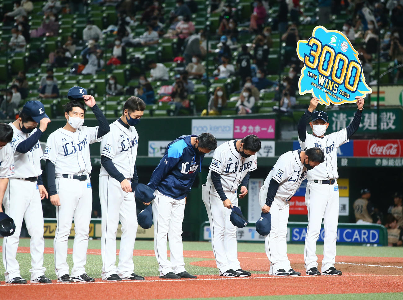 西武対日本ハム　球団通算3000勝を達成し記念のボードを手にスタンドのファンにあいさつする西武辻監督（右端）（撮影・足立雅史）